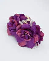 Pinza de pelo tipo pinza de cangrejo con flores de tela en tonos morados y rosados.