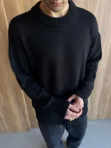 Sweater negro de hilo con cuello redondo y corte clásico.