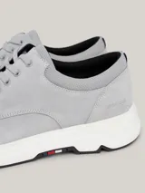 Zapatillas de corte medio color gris claro, con exterior de ante, interior de poliéster reciclado, plantilla extraíble de poliuretano y poliuretano reciclado, suela de goma y caucho, trabilla para calzar distintiva y logo de Tommy Hilfiger en bajo relieve en el lateral y la parte trasera.