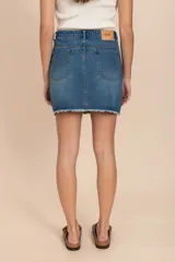 Pollera de jean azul con ruedo desflecado y detalles metalizados.
