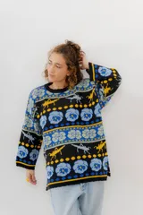 Buzo tejido de jacquard negro con diseños de langostas, flores y formas geométricas en azul y amarillo. Corte oversized con tajos laterales.
