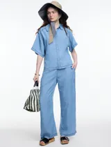 Pantalón celeste de pierna recta y calce relajado, confeccionado en denim 100% lyocell con cintura elástica, bolsillos laterales y pespuntes en color contraste.