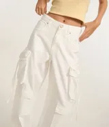 Pantalón baggy de sarga color blanco, con trabillas en la cintura, bolsillos delanteros, traseros y laterales tipo cargo.