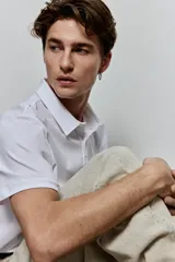 Remera polo blanca de punto de algodón liviano, corte slim fit, con cuello, tapeta de botones y bajo recto.