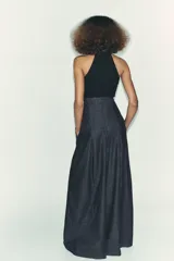 Top negro de cuello halter con cierre de botones en la parte trasera del cuello y espalda descubierta.