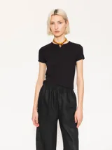 Remera negra de algodón con elastano, de calce ajustado, escote redondo cerrado en el frente, espalda cavada y mangas cortas estilo japonés.