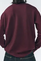 Jersey de punto azul marino confeccionado en 100% lana, de corte recto, con cuello redondo y mangas largas.