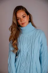 Sweater verde esmeralda de punto trenzado, con cuello alto y mangas largas.