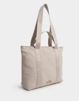 Bolso tipo shopper color beige, con diseño acolchado y pespuntes ondulados. Tiene doble asa de hombro y correa extraíble regulable.