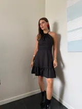 Vestido corto rojo con escote halter, corte a la cintura y falda con volados.