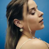 Aros colgantes con argolla de acero quirúrgico hipoalergénico y dije de concha marina con una perla de río natural.