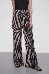 Pantalón de viscosa con estampado abstracto en tonos beige y negro, de corte palazzo y cintura con lazo ajustable.
