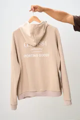 Canguro color beige con capucha, bolsillo tipo canguro y puños y cintura acanalados. Estampado frontal con el logo de la marca Brokers Wear y la frase "Good Time Makers".