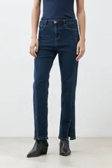 Pantalón de jean azul oscuro, de corte recto, con tajos en el ruedo.