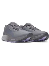 Zapatillas de trail running Under Armour Charged Bandit TR 3 para mujer, color gris con detalles en lila. Presentan una amortiguación Charged y suela con tracción para terrenos fangosos.