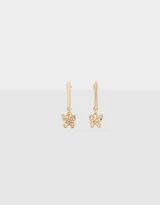 Par de aros colgantes dorados, con barra superior y dije de mariposa con strass.