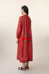 Vestido largo rojo con estampado floral, cuello mao, mangas largas y corte evasé.