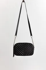 Cartera bandolera negra con diseño capitoneado en forma de V, correa de cuero y cadena plateada, cierre metálico y doble bolsillo interior.