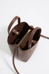 Bolso de piel regenerada color marrón, con estructura rígida y cierre de snap, ideal para uso diario.