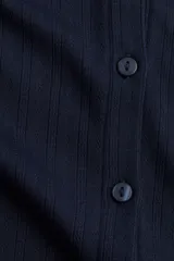 Saco azul marino de punto pointelle suave, entallado, con cuello redondo y cierre frontal con botones.