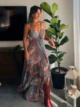 Vestido largo con estampado floral, escote halter y corte asimétrico con volados.