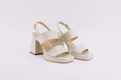 Sandalias de plataforma color borgoña, confeccionadas en charol. Tienen dos tiras anchas sobre el empeine, pulsera con hebilla al tobillo y taco cuadrado de 9 cm.