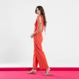Mono estampado en verde con botones frontales y tirantes ajustables.