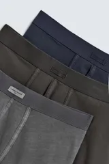 Pack de tres calzoncillos tipo bóxer en colores gris, verde oliva y azul marino, con cintura elástica.