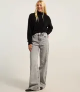 Suéter negro de punto con hilos metálicos, cuello alto y mangas largas.