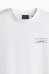 Remera blanca de algodón con cuello redondo y estampado de texto en el pecho.