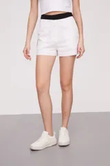 Short de lino blanco con cintura alta negra y corte recto.