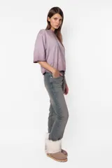 Remera de jersey color lila con efecto desgastado, corte Boxy fit, cuello alto en Rib al tono y manga corta. Estampa láser en el delantero.