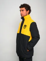 Parka de hombre bicolor negra y amarilla con escudo del club deportivo Peñarol en el pecho.