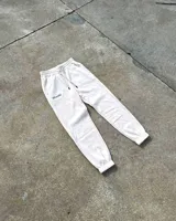 Pantalón de jogging color crema, corte holgado, con cintura elástica ajustable con cordón, puños elásticos y logo bordado en tono a tono.