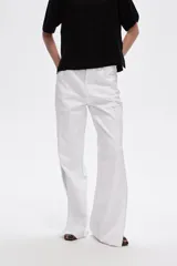 Pantalón de jean azul de tiro alto, corte recto y aberturas laterales en el ruedo.