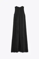 Vestido midi negro de cuello redondo y sin mangas. Corte amplio y fluido, con bolsillos laterales ocultos y cierre trasero con cremallera invisible.