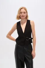 Chaleco negro sin mangas con escote en V y cierre cruzado con hebilla metálica.