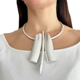 Collar rígido plateado con tres colgantes geométricos texturizados.