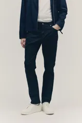 Pantalón de corte slim fit color negro, confeccionado en sarga de algodón, con cinco bolsillos, cierre con cremallera y botón.