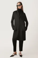 Pantalón negro de tiro alto con cintura con trabillas, bolsillos delanteros y raya planchada.