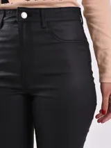 Pantalón chupín de cuero sintético color negro, tiro alto y corte ajustado.