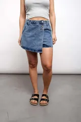 Short pollera de jean celeste con tres botones frontales.