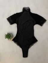 Body negro de lycra entallado con detalles de microtul y encaje, cuello alto y espalda descubierta.