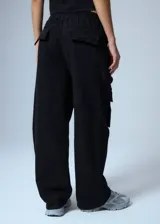 Pantalón cargo de denim negro, con cintura elástica y grandes bolsillos cargo a los lados con botones metálicos plateados.