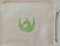 Sobre pequeño de tela color crudo con cierre superior y cadena metálica plateada. Presenta bordadas las iniciales AF en color verde.