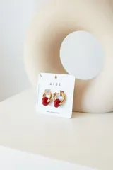 Aros de acero quirúrgico hipoalergénico con piedras naturales azules. Diseño de aro con dije circular colgante.