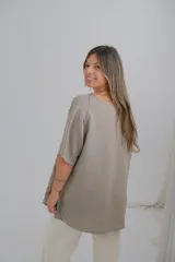 Blusa color visón con estampado de hojas en tonos marrones, de corte holgado y mangas cortas.