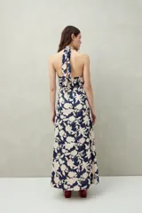 Vestido largo de algodón liviano con estampado floral en tonos azul y blanco, escote halter y lazo que se anuda al cuello.