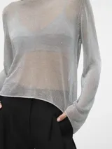 Remera plateada de tejido de punto calado con hilos metálicos, cuello redondo y mangas largas.