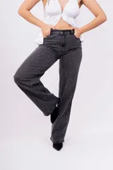 Pantalón de jean negro de corte wide leg con estampa de pequeñas estrellas blancas.